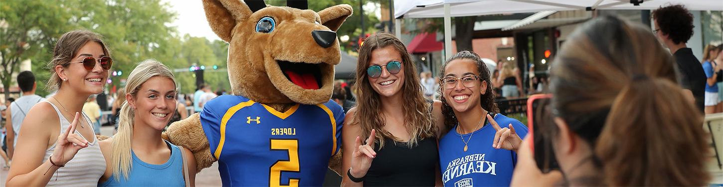 学生 pose with Louie the Loper at the Destination Downtown event